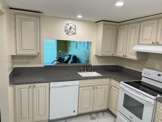 kitchen with sink, white appliances, and cream cabinets