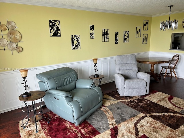 sitting room featuring dark wood-type flooring, a textured ceiling, and ornamental molding