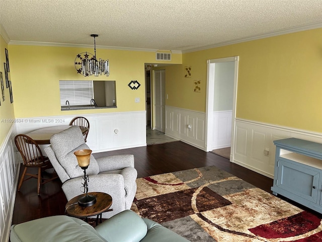 living room with dark wood-type flooring, a notable chandelier, crown molding, and a textured ceiling