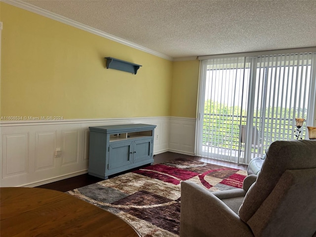 living room with dark wood-type flooring, a textured ceiling, and ornamental molding