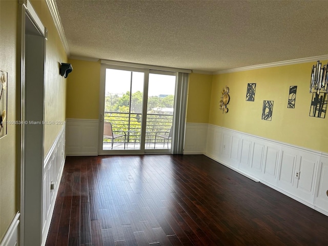 spare room with a textured ceiling, ornamental molding, and dark hardwood / wood-style floors