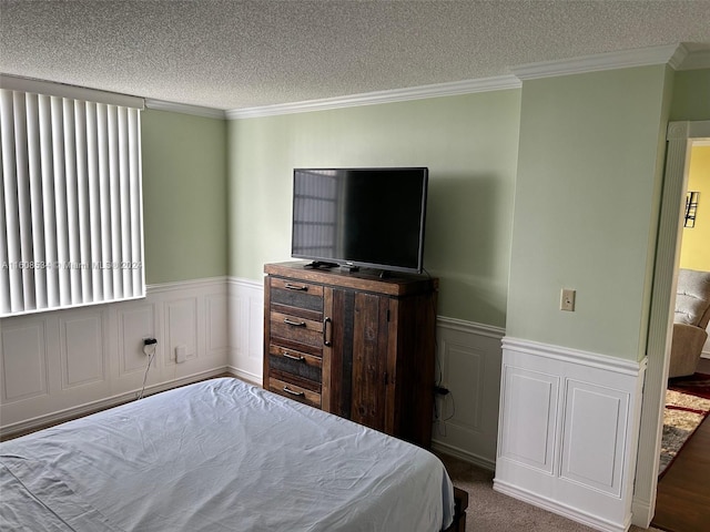 bedroom with a textured ceiling, ornamental molding, and carpet flooring