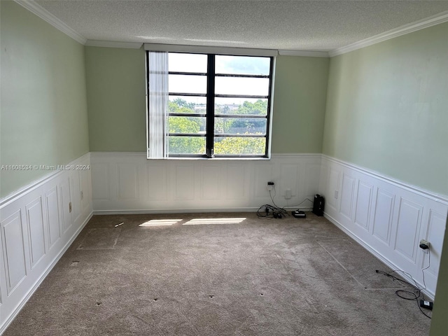 unfurnished room featuring carpet floors, a textured ceiling, and ornamental molding