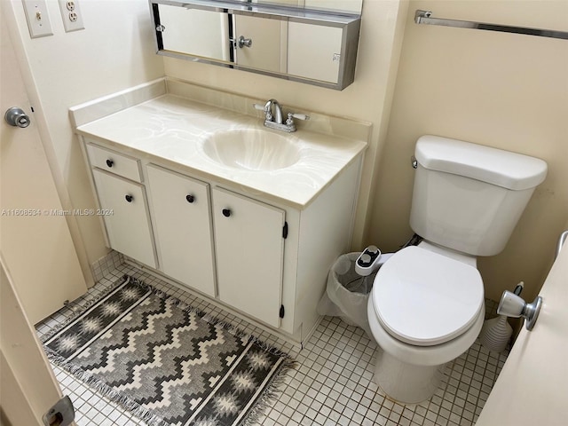 bathroom featuring toilet, vanity, and tile patterned flooring