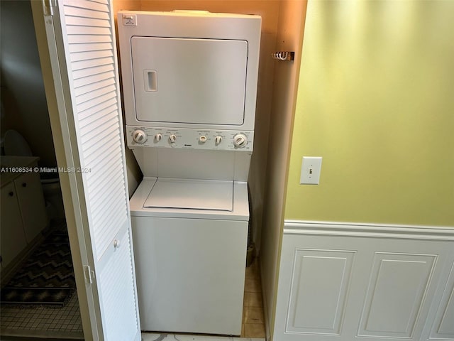 laundry area featuring tile patterned floors and stacked washer and clothes dryer