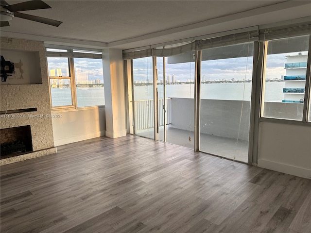 unfurnished living room with ceiling fan, dark hardwood / wood-style flooring, and a fireplace