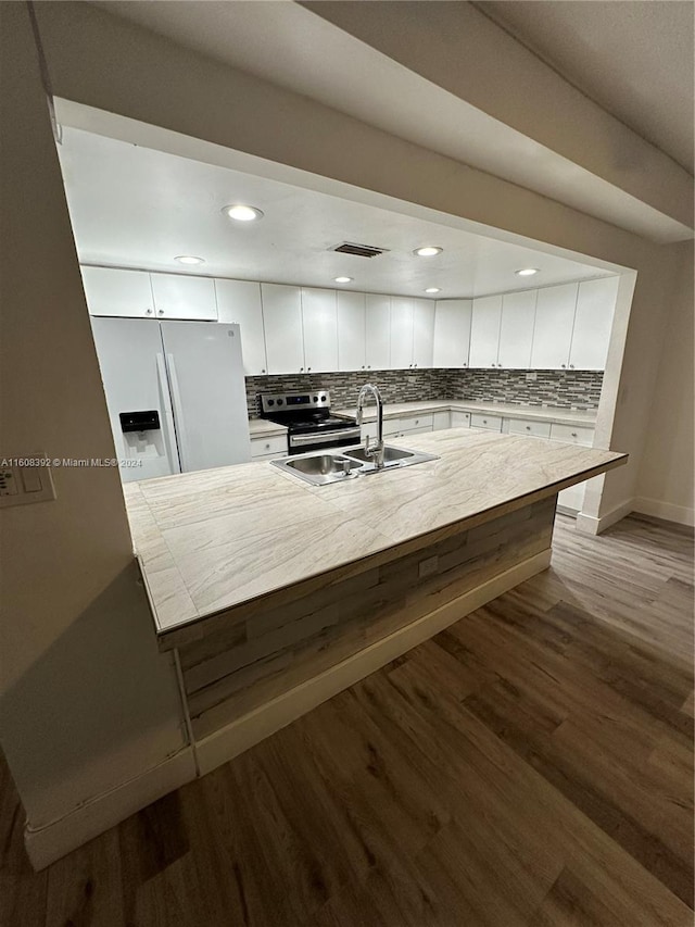 kitchen with backsplash, wood-type flooring, white cabinetry, and white fridge with ice dispenser