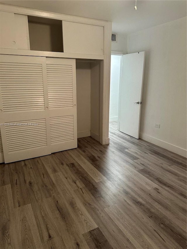 unfurnished bedroom featuring a closet and wood-type flooring