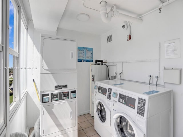 washroom featuring independent washer and dryer, light tile flooring, washer hookup, stacked washer / drying machine, and electric water heater