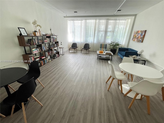 living area with wood-type flooring and expansive windows