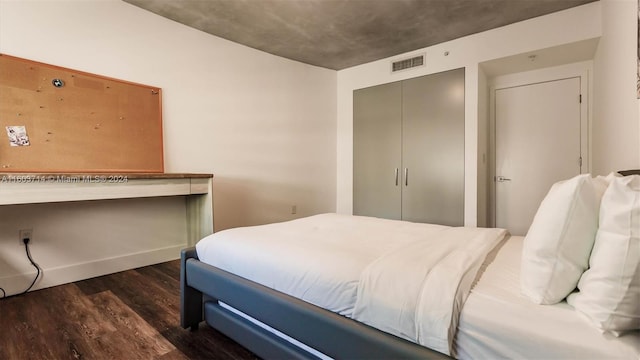 bedroom with a closet and dark wood-type flooring