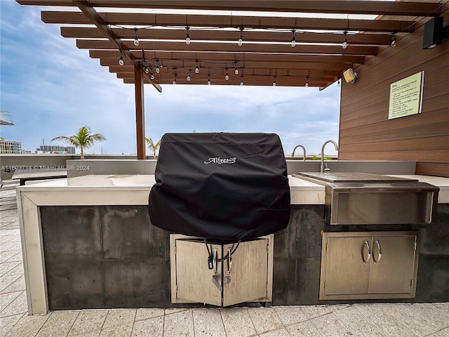 view of patio with a pergola, a grill, and an outdoor kitchen