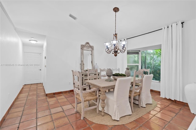 dining space with a notable chandelier, tile flooring, and vaulted ceiling