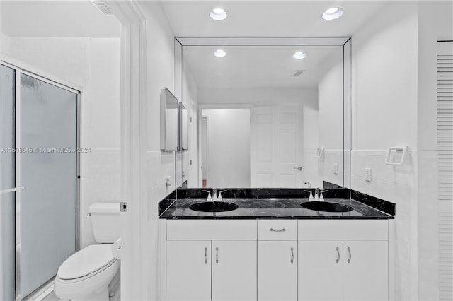 bathroom with vanity with extensive cabinet space, dual sinks, and toilet