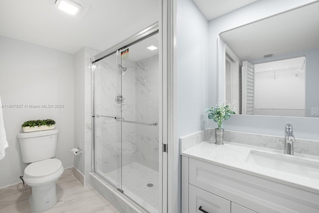 bathroom featuring walk in shower, vanity, and toilet