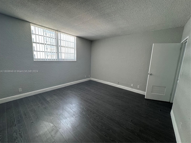 spare room with a textured ceiling and hardwood / wood-style floors