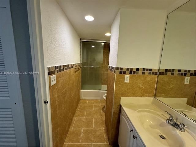 full bathroom featuring tile walls, tiled shower / bath combo, tile patterned flooring, vanity, and toilet