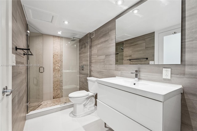 bathroom with tile flooring, vanity with extensive cabinet space, an enclosed shower, tile walls, and toilet