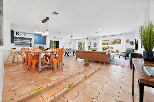 tiled dining area with an inviting chandelier and plenty of natural light