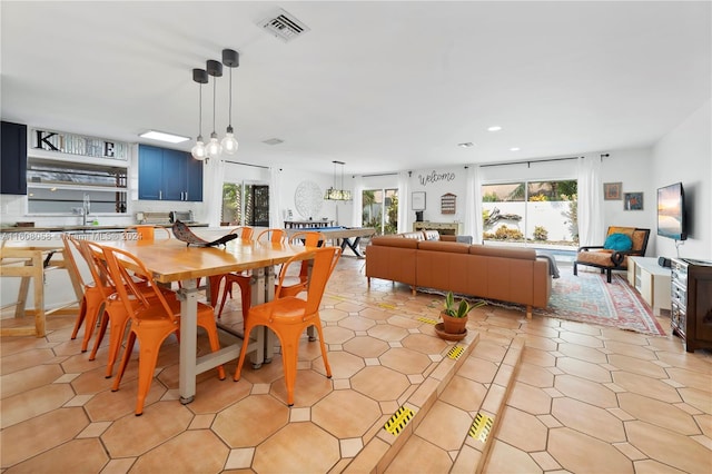 dining room with a notable chandelier, light tile patterned flooring, and sink