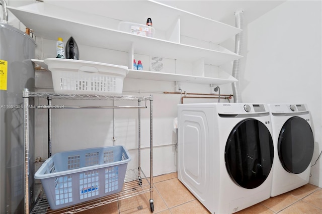 laundry area with washer and clothes dryer and light tile patterned floors