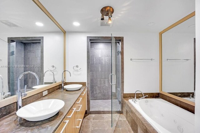 bathroom with vanity, a relaxing tiled tub, and toilet