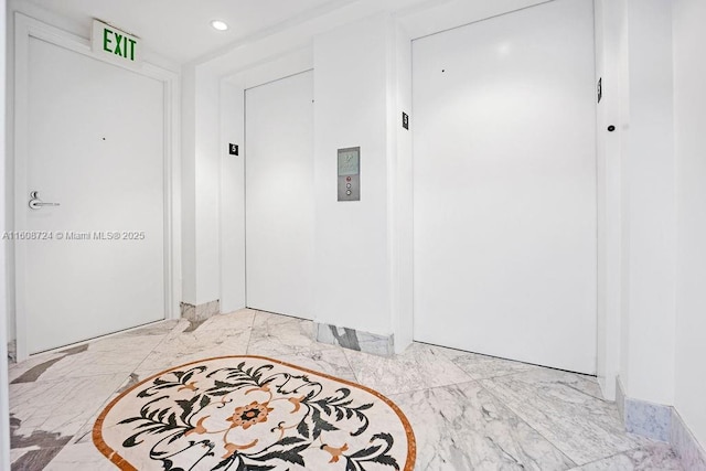 foyer entrance featuring marble finish floor, elevator, and recessed lighting