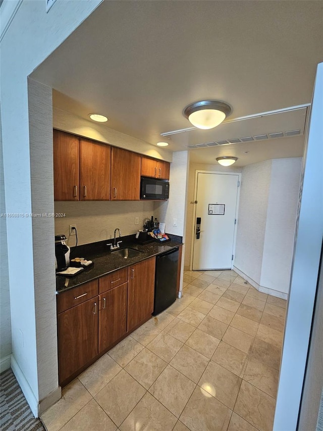 kitchen featuring black appliances, sink, and light tile patterned floors