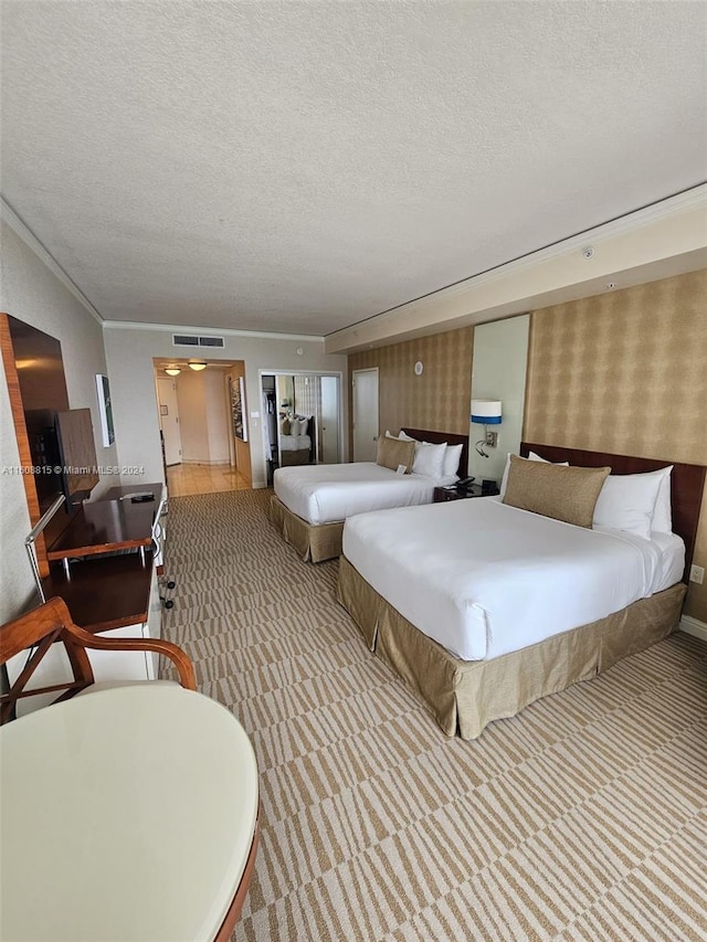 carpeted bedroom with a textured ceiling and crown molding