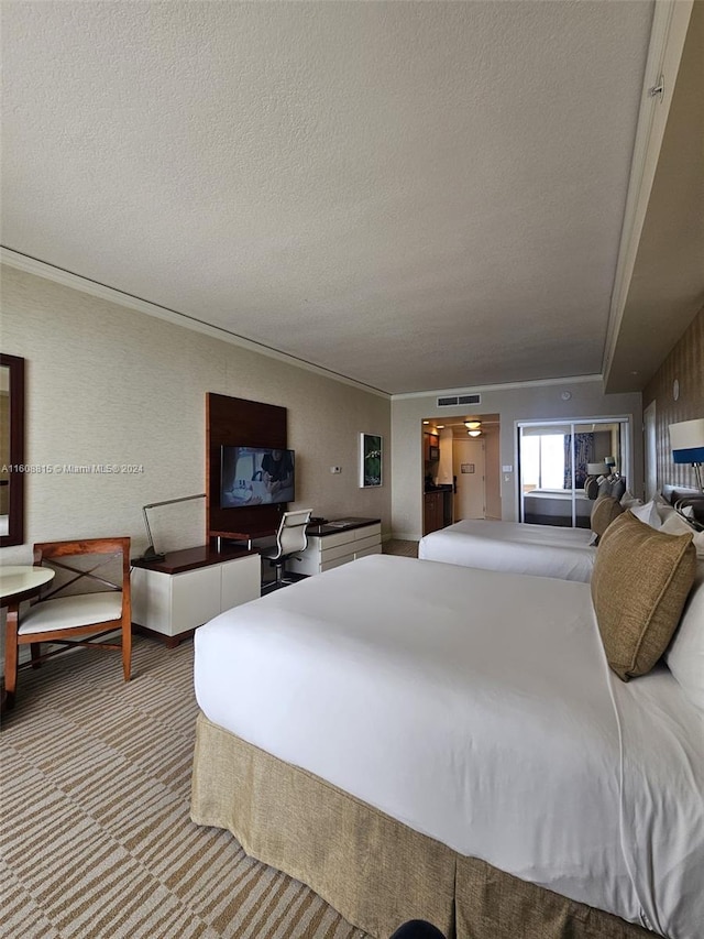 bedroom with a textured ceiling, carpet, and crown molding