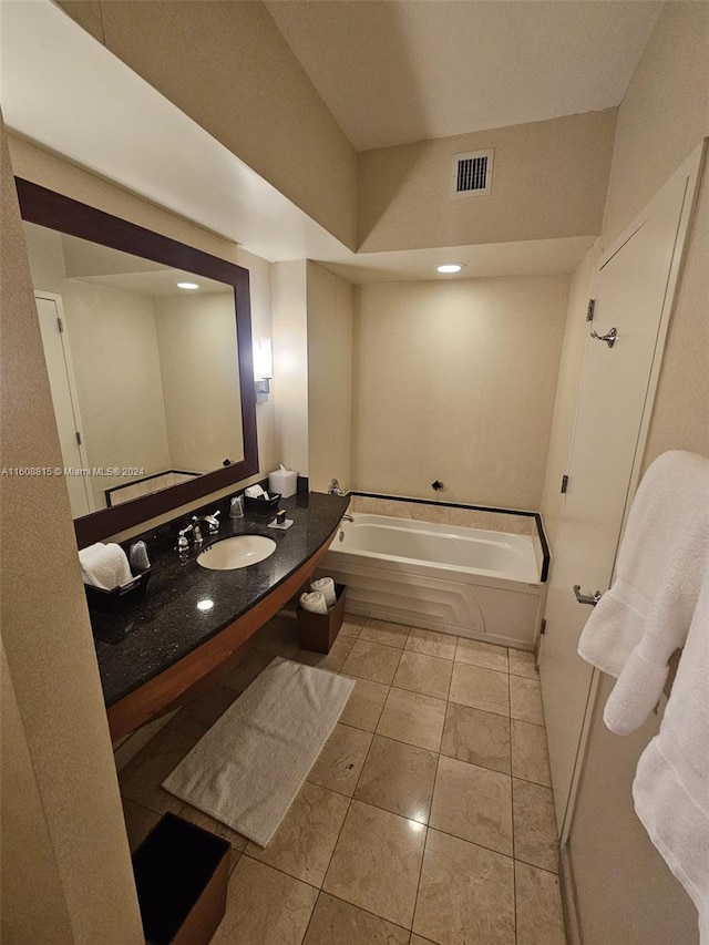 bathroom featuring vanity, tile patterned flooring, and a bathtub