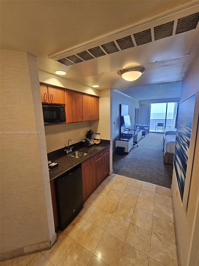 kitchen featuring sink, black appliances, and light carpet