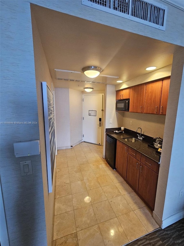 kitchen featuring light tile patterned flooring, black appliances, and sink