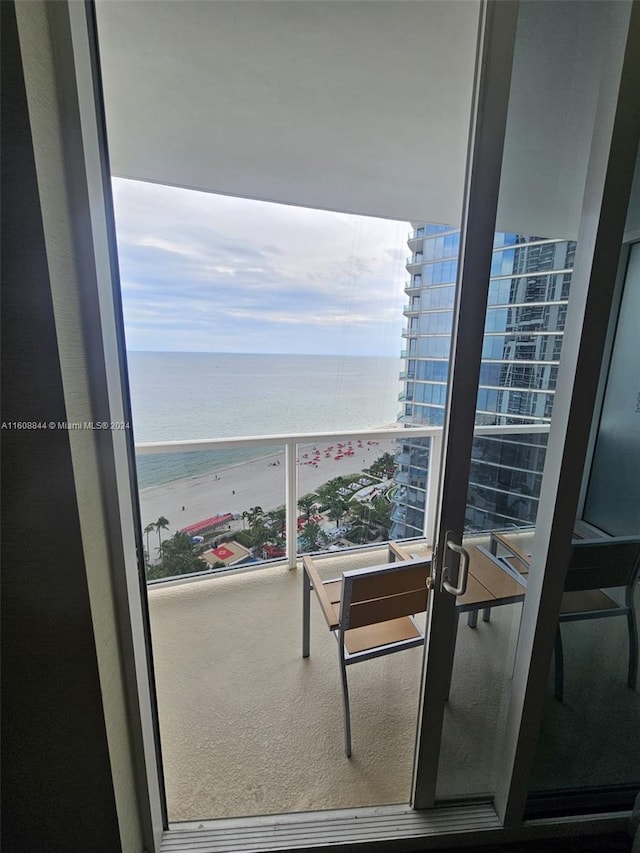 balcony featuring a water view and a view of the beach