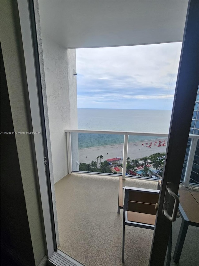 balcony featuring a water view and a view of the beach