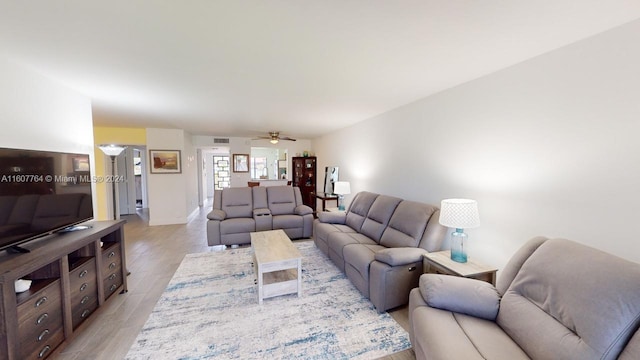 living room featuring ceiling fan and light hardwood / wood-style floors