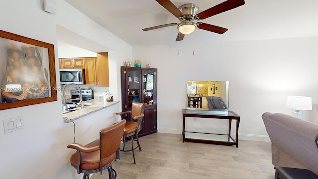 home office with ceiling fan and light wood-type flooring