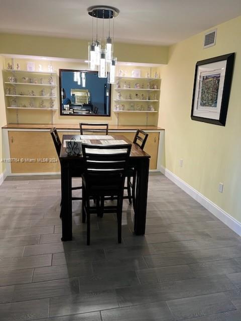 dining space with dark hardwood / wood-style floors and an inviting chandelier