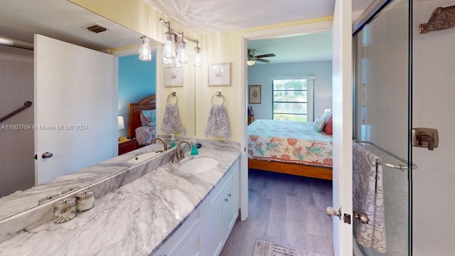 bathroom with a shower with door, large vanity, ceiling fan, and hardwood / wood-style floors