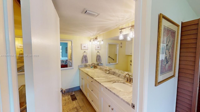 bathroom with hardwood / wood-style flooring and dual bowl vanity