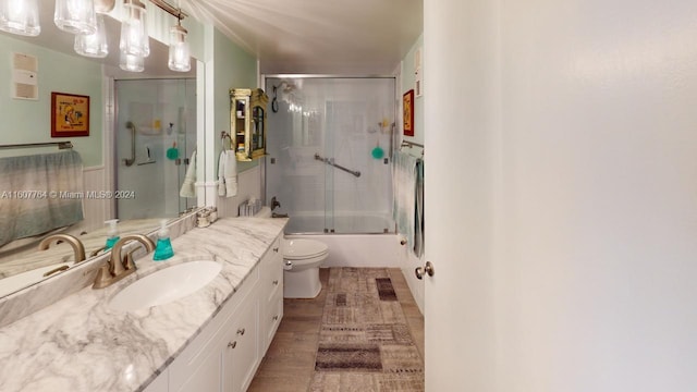 full bathroom with vanity with extensive cabinet space, enclosed tub / shower combo, and toilet