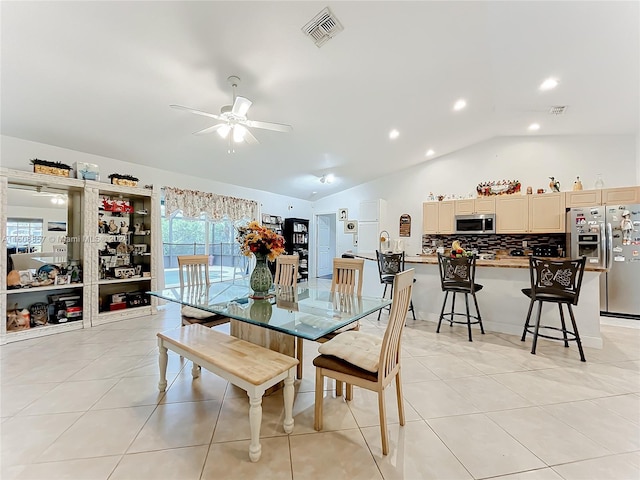 tiled dining room with ceiling fan and lofted ceiling