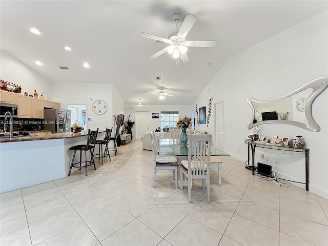 tiled dining space featuring sink, ceiling fan, and lofted ceiling