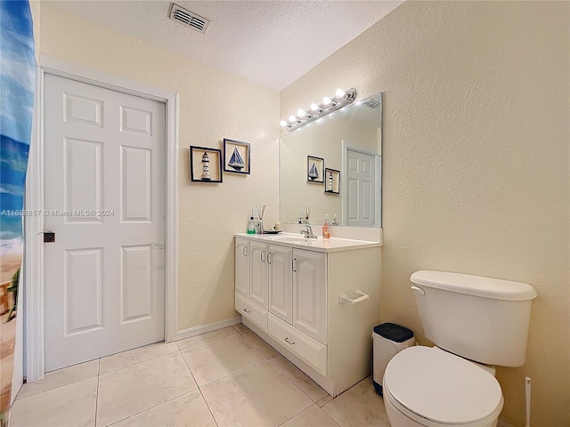 bathroom with tile floors, a textured ceiling, toilet, and vanity