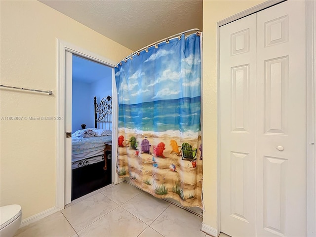 bathroom with tile floors and toilet