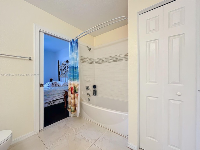 bathroom with tile flooring, toilet, and shower / tub combo