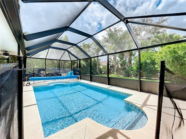 view of swimming pool featuring a lanai and a patio area