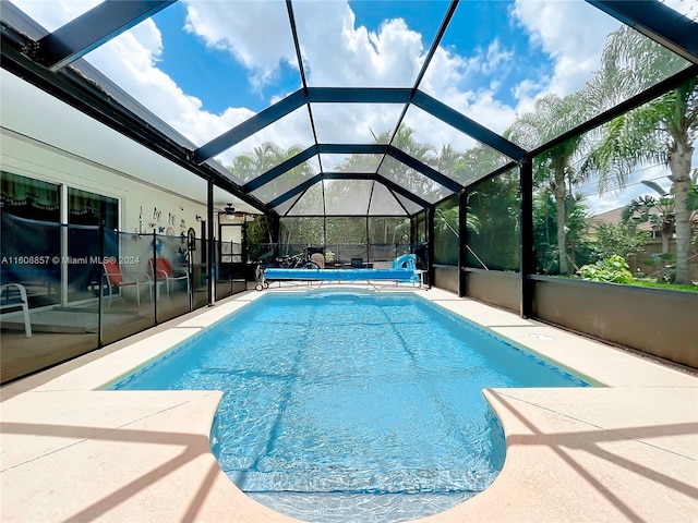 view of swimming pool featuring a patio and a lanai