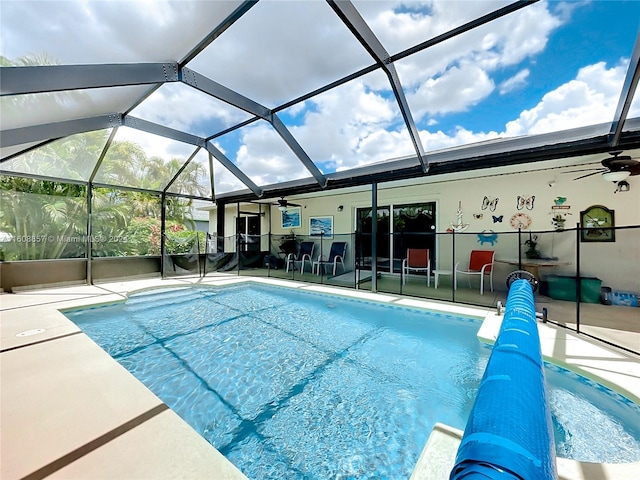 view of swimming pool with ceiling fan, a lanai, and a patio