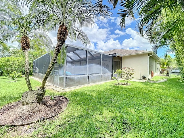 exterior space with glass enclosure and a yard